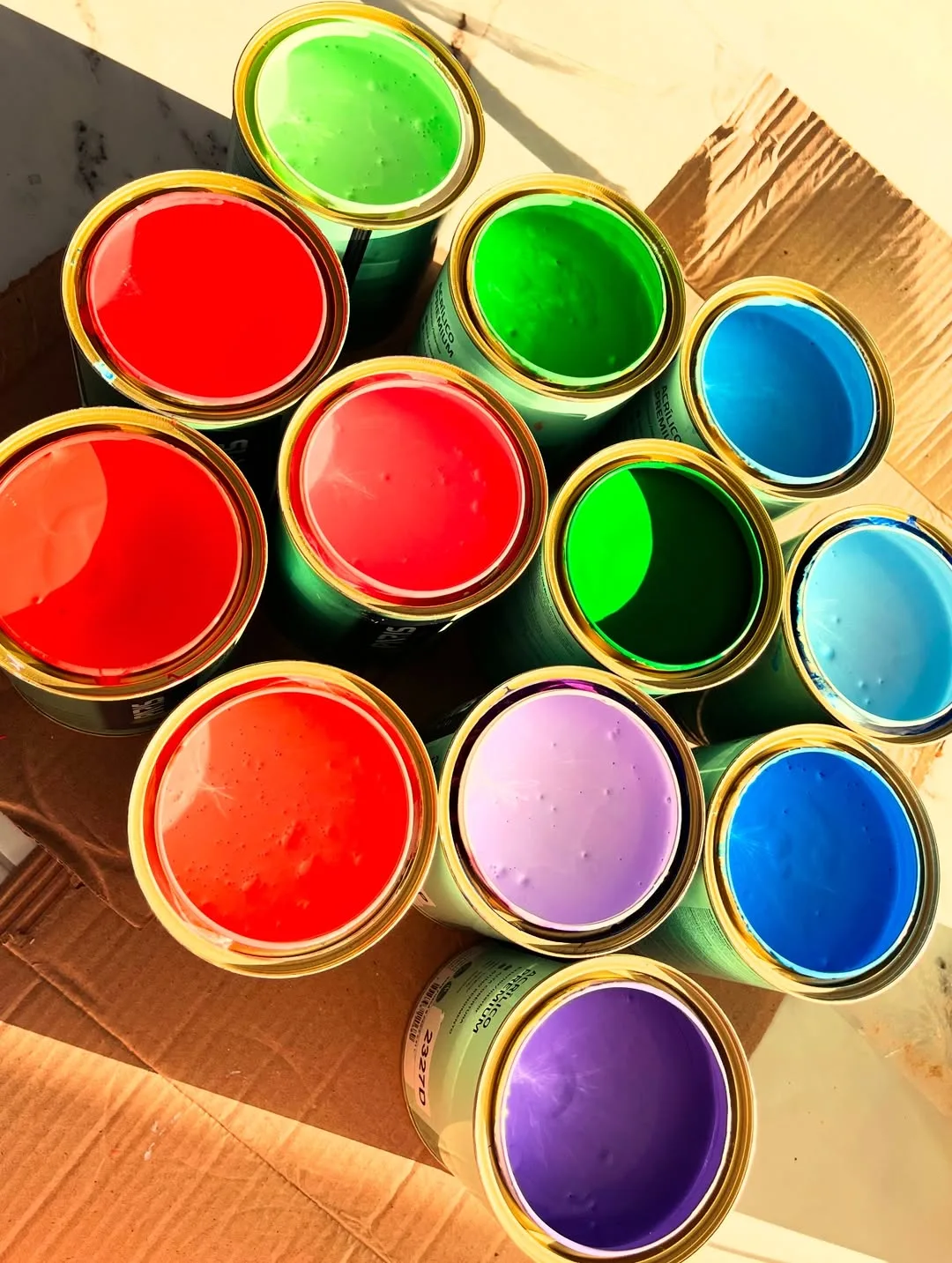 Latas abertas de tinta Paris do Brasil em cores vibrantes